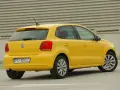Żółty Volkswagen Polo widziany z tyłu, z widocznym tylnym światłem i tablicą rejestracyjną.
