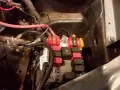 Skrzynka z bezpiecznikami w Fiat Doblo. Widać kolorowe bezpieczniki i przekaźniki.