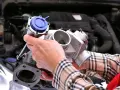 Mechanik trzyma turbosprężarkę, pokazując, gdzie znajduje się czujnik ciśnienia doładowania.
