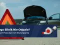 Awaryjny trójkąt i otwarty bagażnik czarnego auta sugerują problem z odpalaniem na ciepłym silniku benzyna.