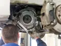 Mechanik dokręca śruby docisku sprzęgła. Wymiana sprzęgła krok po kroku w trakcie naprawy samochodu.
