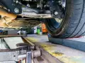 Podczas regulacji geometrii zawieszenia w warsztacie samochodowym, mechanik precyzyjnie ustawia kąty kół.