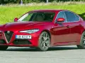Czerwona Alfa Romeo Giulia, zgrabna sylwetka i mocne silniki, gotowa do jazdy.