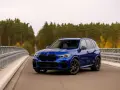 Niebieskie BMW X5 na moście, otoczone jesiennym lasem. Idealne do rozkodowanie vin bmw.