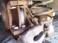 Wymiana klocków hamulcowych Opel Astra H tył. Widoczny skorodowany zacisk i tarcza hamulcowa, gotowe do montażu nowych klocków.