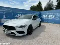 Biały Mercedes na tle niebieskiego banera AMAG Auto Komis. Idealny do akcje serwisowe Mercedes.