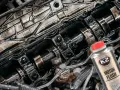 Silnik Peugeot 307 1.6 benzyna po płukaniu. Widać wałki rozrządu i elementy pokryte olejem. Obok butelka płukanki K2 Motor Flush.