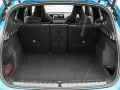 Otwarty bagażnik BMW X1, gotowy na podróż. Widoczne sportowe fotele i siatka z czerwoną gaśnicą.