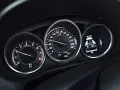 Zbliżenie na deskę rozdzielczą samochodu: obrotomierz pokazuje ok. 1500 obr./min, prędkościomierz ok. 60 km/h, a wyświetlacz i-ELOOP informuje o ładowaniu.
