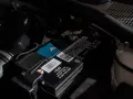 Akumulator w Audi Q7 znajduje się pod maską, obok filtra powietrza. Widoczny jest też niebieski gadżet z logo Cupra.