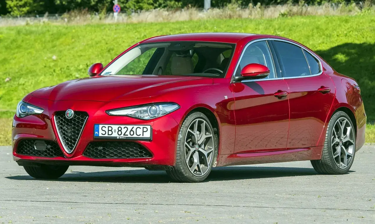 Czerwona Alfa Romeo Giulia, zgrabna sylwetka i mocne silniki, gotowa do jazdy.