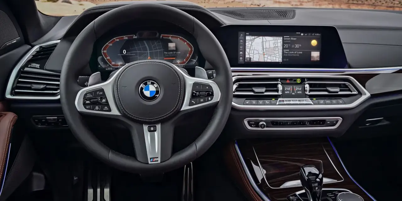 Wnętrze BMW z systemem BMW Live Cockpit Professional. Kierownica, ekran nawigacji i panel klimatyzacji.
