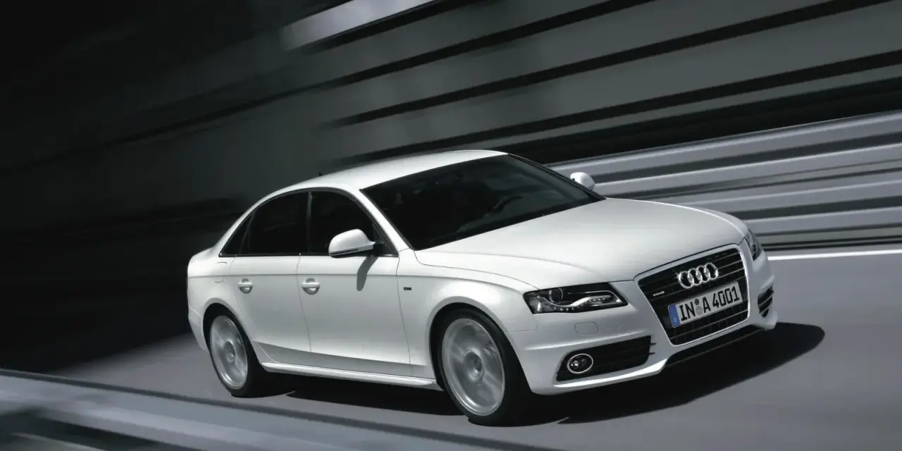 Białe Audi A4 B8 2.0 TDI 143KM w ruchu, z widocznymi felgami i grillem.