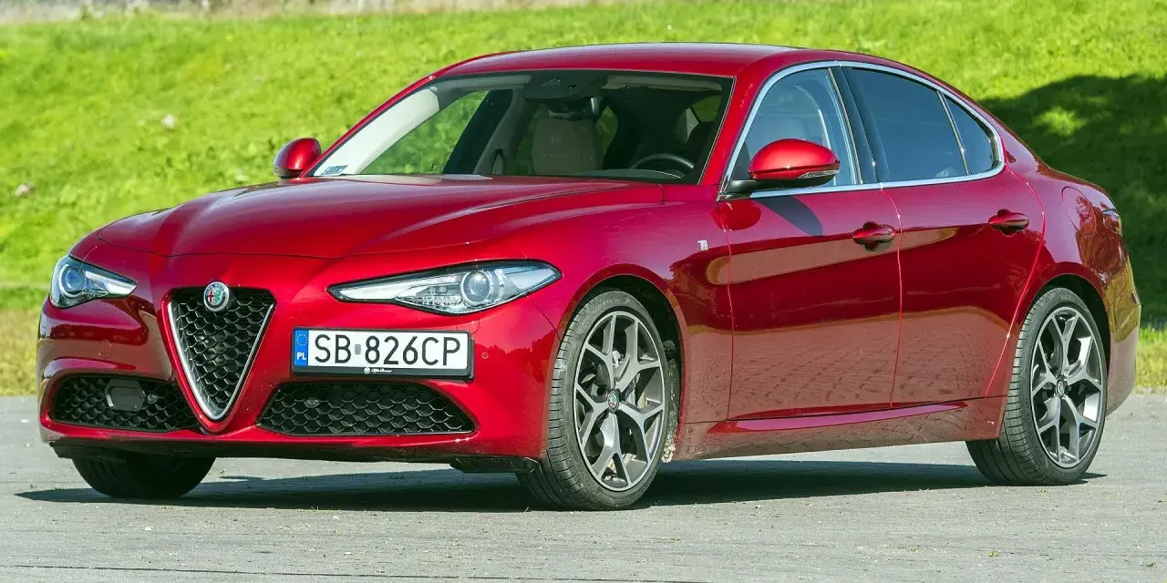 Czerwona Alfa Romeo Giulia, zgrabna sylwetka i mocne silniki, gotowa do jazdy.