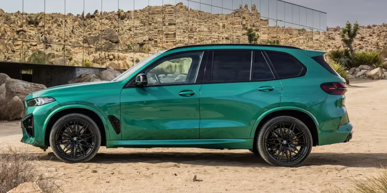 Zielony, sportowy SUV z czarnymi felgami, zaparkowany na pustyni. To ekonomiczne auto, które przyciąga wzrok.