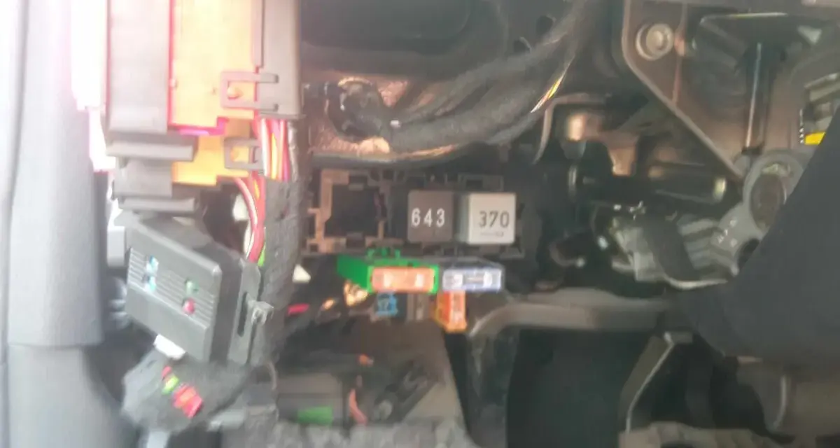 Audi A4 B8 bezpieczniki opis. Widok na skrzynkę bezpieczników i przekaźników pod deską rozdzielczą.