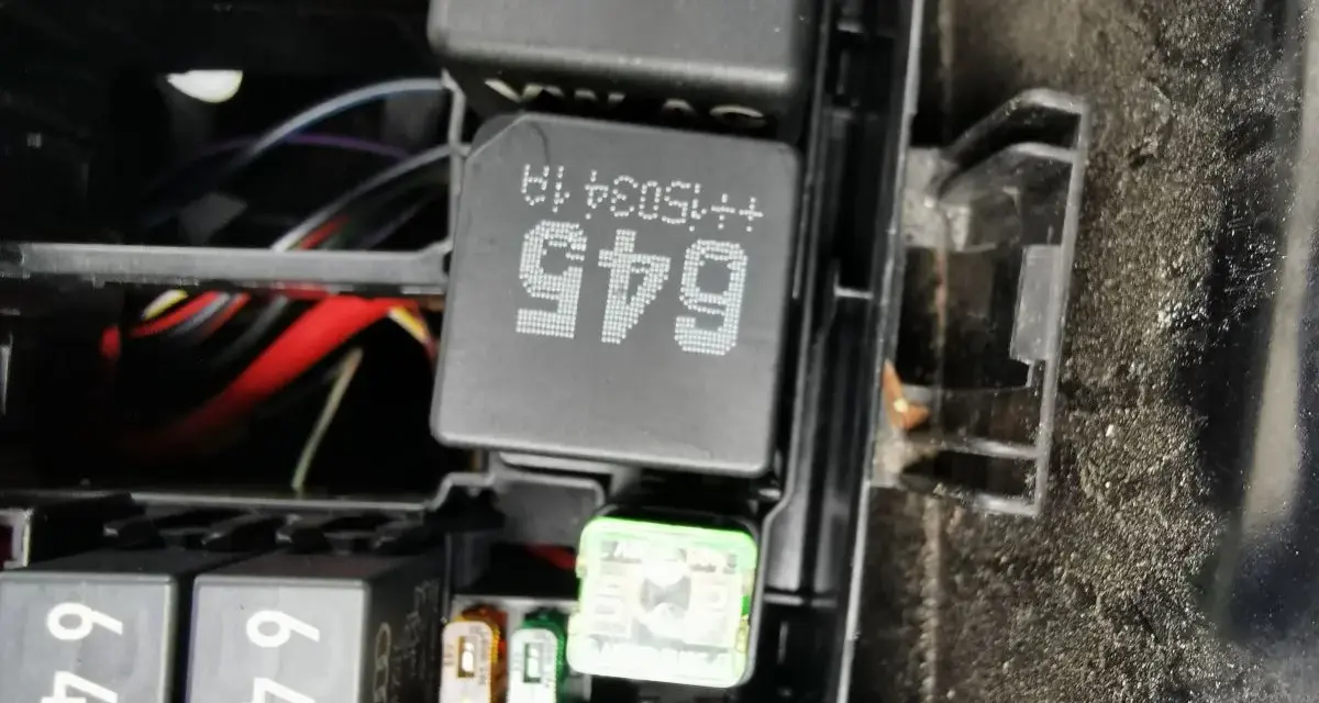 Wnętrze skrzynki z bezpiecznikami i przekaźnikami w Passacie B8. Widoczne przekaźniki z oznaczeniami 645 i 45, a także bezpieczniki.