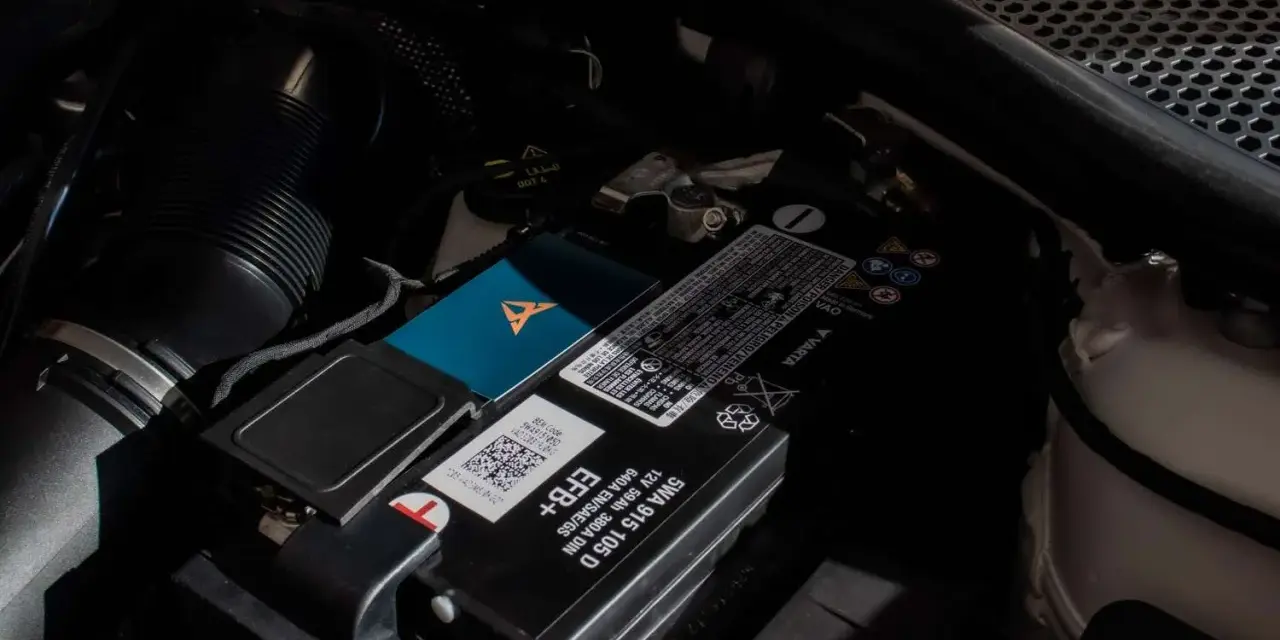 Akumulator w Audi Q7 znajduje się pod maską, obok filtra powietrza. Widoczny jest też niebieski gadżet z logo Cupra.