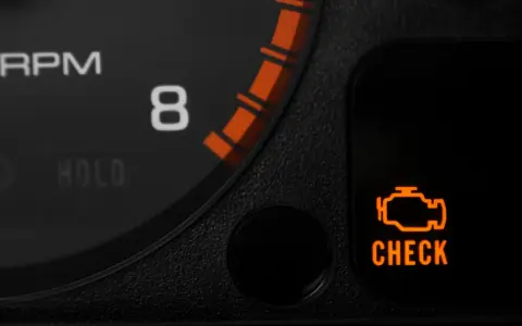 Pomarańczowa kontrolka "CHECK ENGINE" świeci się na desce rozdzielczej. To sygnał, że silnik wymaga uwagi, może to być związane z wymianą oleju lub inną usterką.