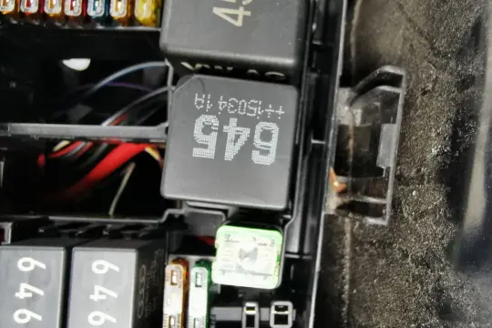 Wnętrze skrzynki z bezpiecznikami i przekaźnikami w Passacie B8. Widoczne przekaźniki z oznaczeniami 645 i 45, a także bezpieczniki.