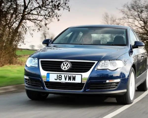 Ciemnoniebieski Passat B6 jedzie po krętej drodze. Zastanawiasz się, jakie żarówki Passat B6 przód wybrać?