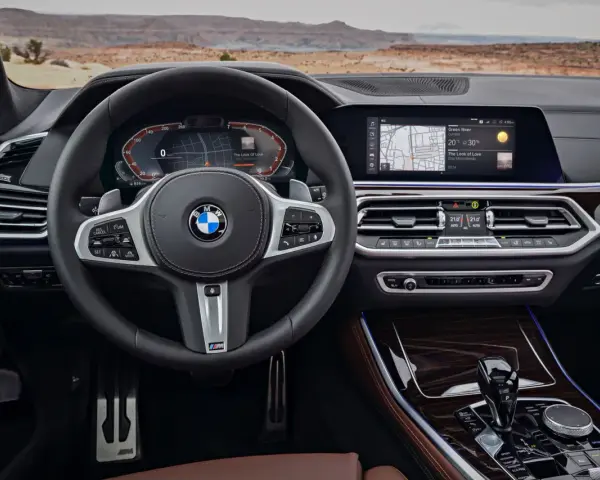 Wnętrze BMW z systemem BMW Live Cockpit Professional. Kierownica, ekran nawigacji i panel klimatyzacji.
