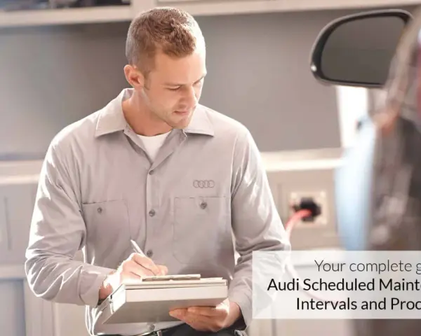 Mechanik z logo Audi na koszulce notuje szczegóły w dokumencie. Twój kompletny przewodnik po **Audi plan serwisowy**.