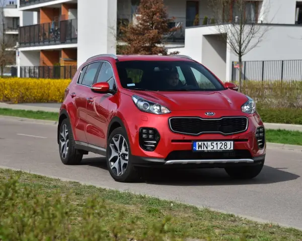 Czerwony Kia Sportage 4 na drodze, gotowy do wymiany żarówki.