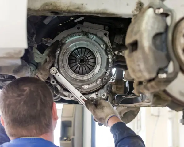 Mechanik dokręca śruby docisku sprzęgła. Wymiana sprzęgła krok po kroku w trakcie naprawy samochodu.