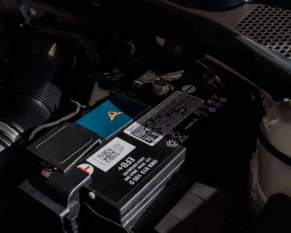 Akumulator w Audi Q7 znajduje się pod maską, obok filtra powietrza. Widoczny jest też niebieski gadżet z logo Cupra.