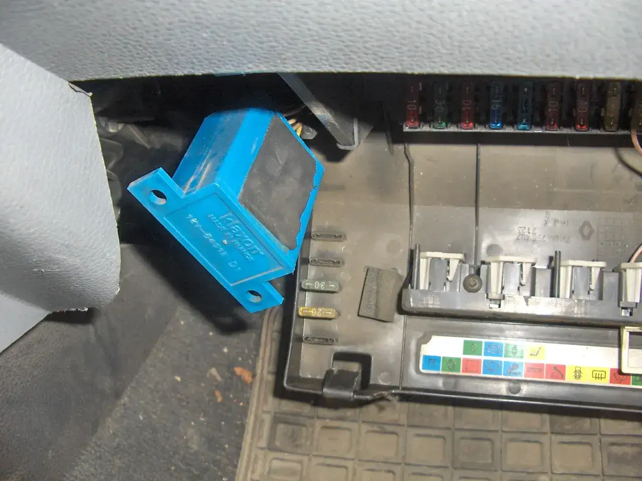 Skrzynka bezpieczników w Renault Clio 3. Widoczny niebieski moduł i opis bezpieczników.