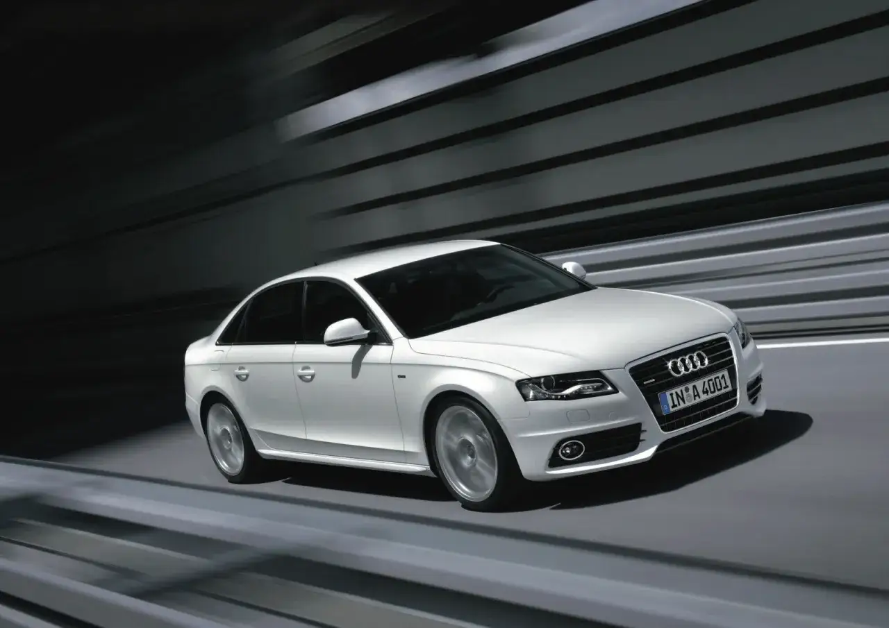 Białe Audi A4 B8 2.0 TDI 143KM w ruchu, z rozmytym tłem. Czy są jakieś wady tego modelu?