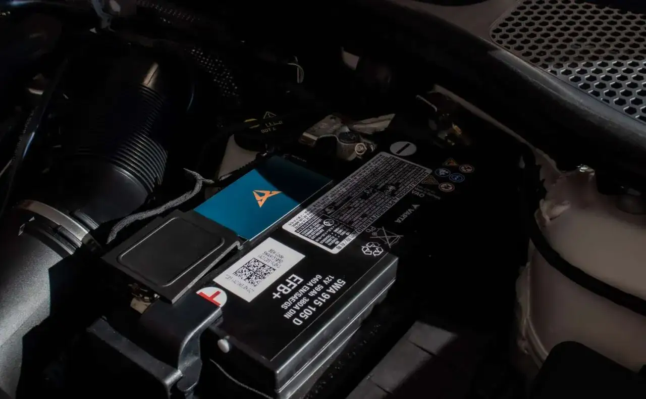 Akumulator w Audi Q7 znajduje się pod maską, obok czarnej obudowy filtra powietrza. Jest to model Varta EFB+.