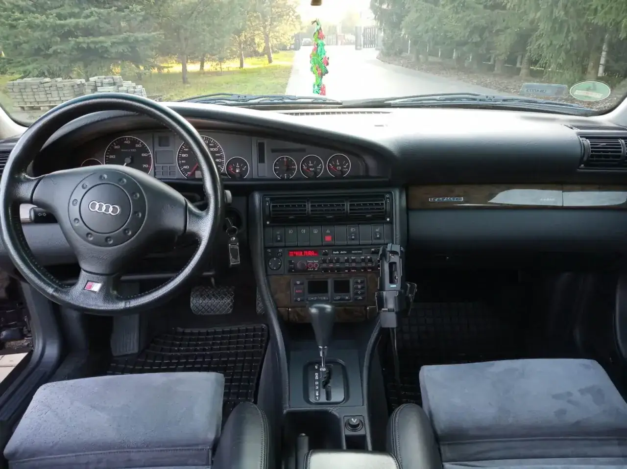 Wnętrze Audi A6 C4 z drewnianymi wstawkami i radiem