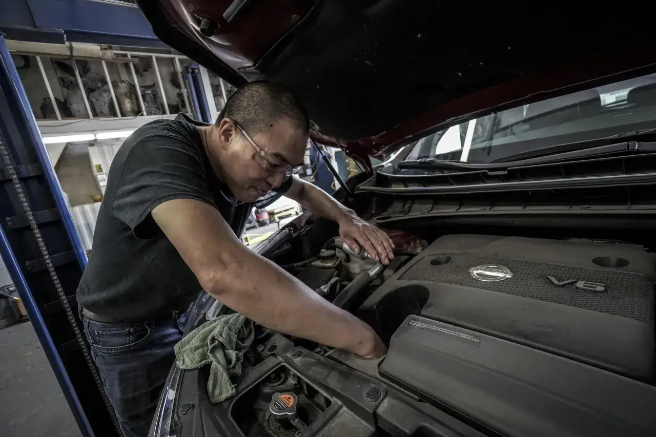 Mechanik pracuje przy silniku V6, być może rozwiązując problem z rozrusznikiem na krótko.