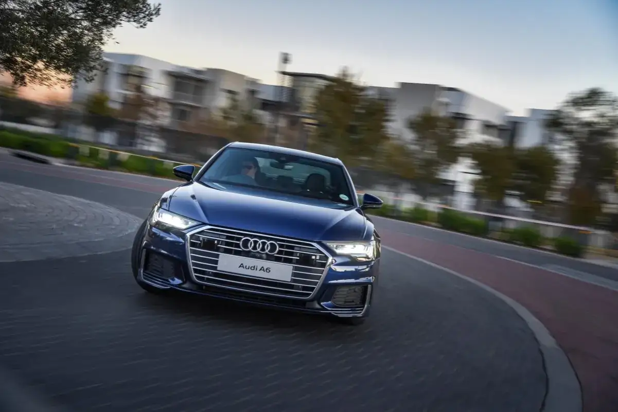Niebieskie Audi A6 C8 w ruchu, z rozmazanym tłem. Nawet luksusowe auta mogą mieć usterki.