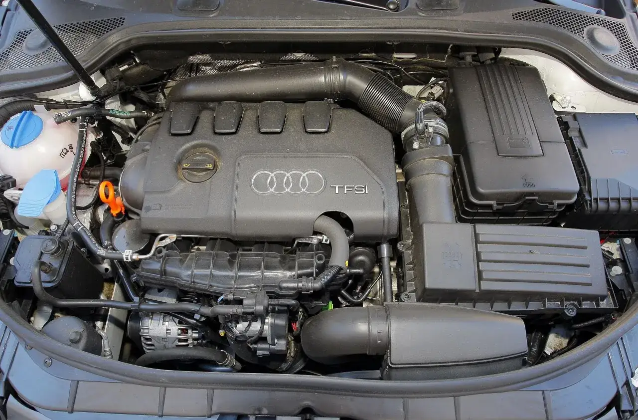 Silniki Audi A3 TFSI, widok komory silnika z elementami układu dolotowego i osprzętem.