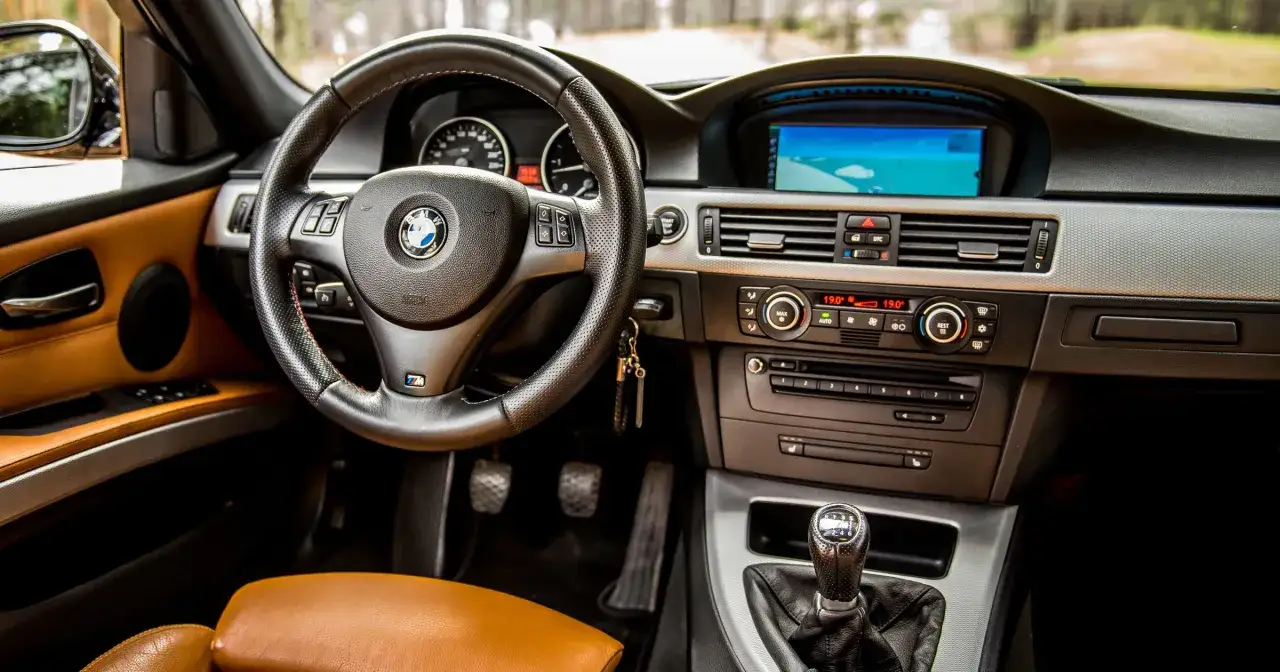 Wnętrze BMW z brązową tapicerką, kierownicą M i nawigacją. Idealne do planowania podróży i przeglądów.